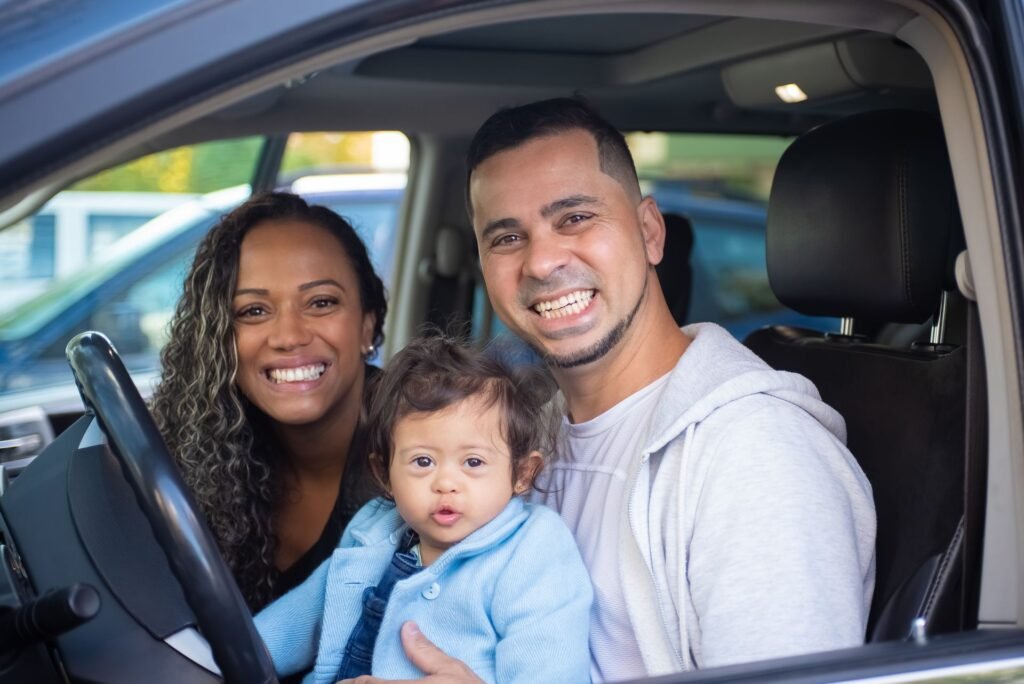 Família feliz dentro do carro novo